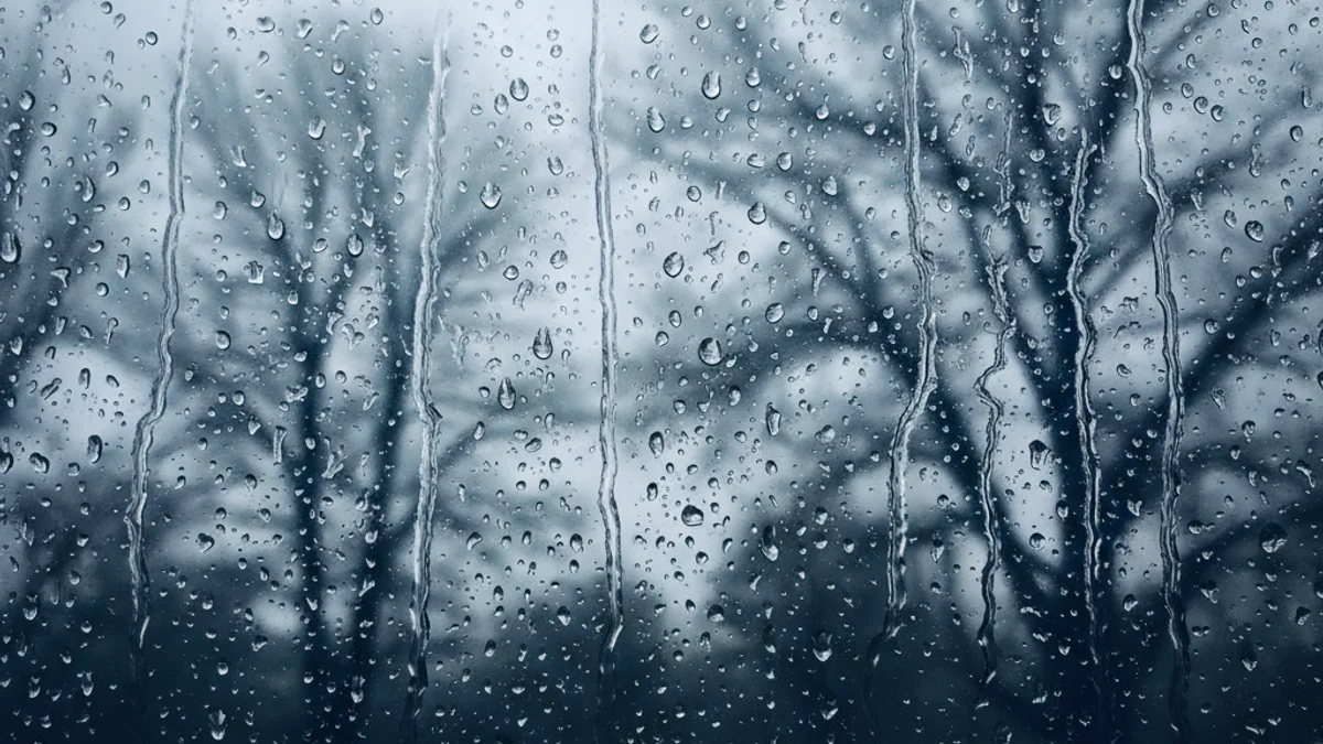 Imatge genèrica d'un paisatge plujós amb núvols foscos i gotes d'aigua sobre un vidre.