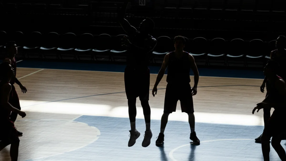 Imatge genèrica d'un partit de bàsquet amb jugadors en acció sota la cistella, sense cares visibles.