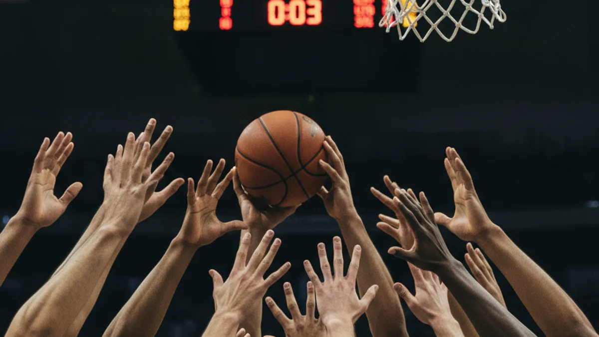 Imatge genèrica d'un partit de bàsquet en un moment de tensió, amb jugadors en acció prop de la cistella.