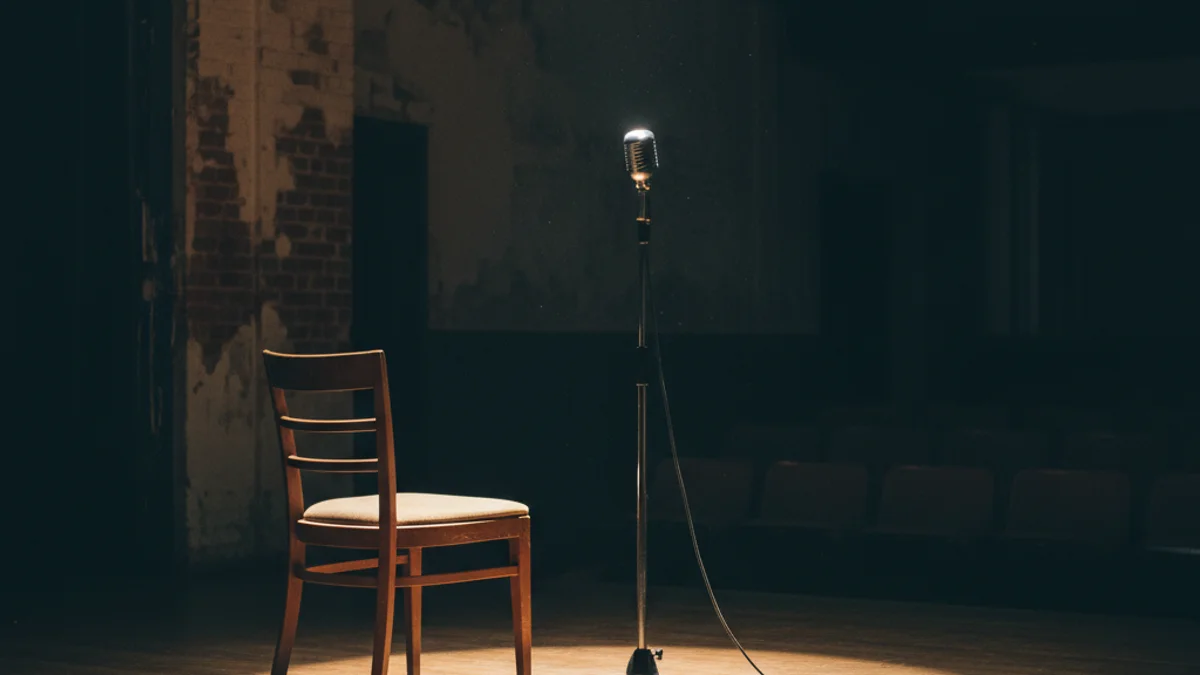 Escenari buit amb un micròfon, simbolitzant el diàleg i les arts escèniques.