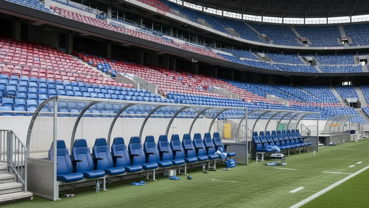 Una banqueta de futbol buida en un estadi gran, simbolitzant un canvi d'entrenador.