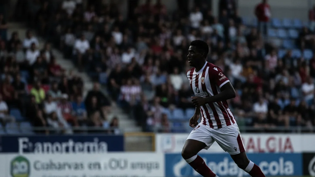 Imatge genèrica d'un partit de futbol de Primera RFEF, amb jugadors en acció i un estadi ple de públic.