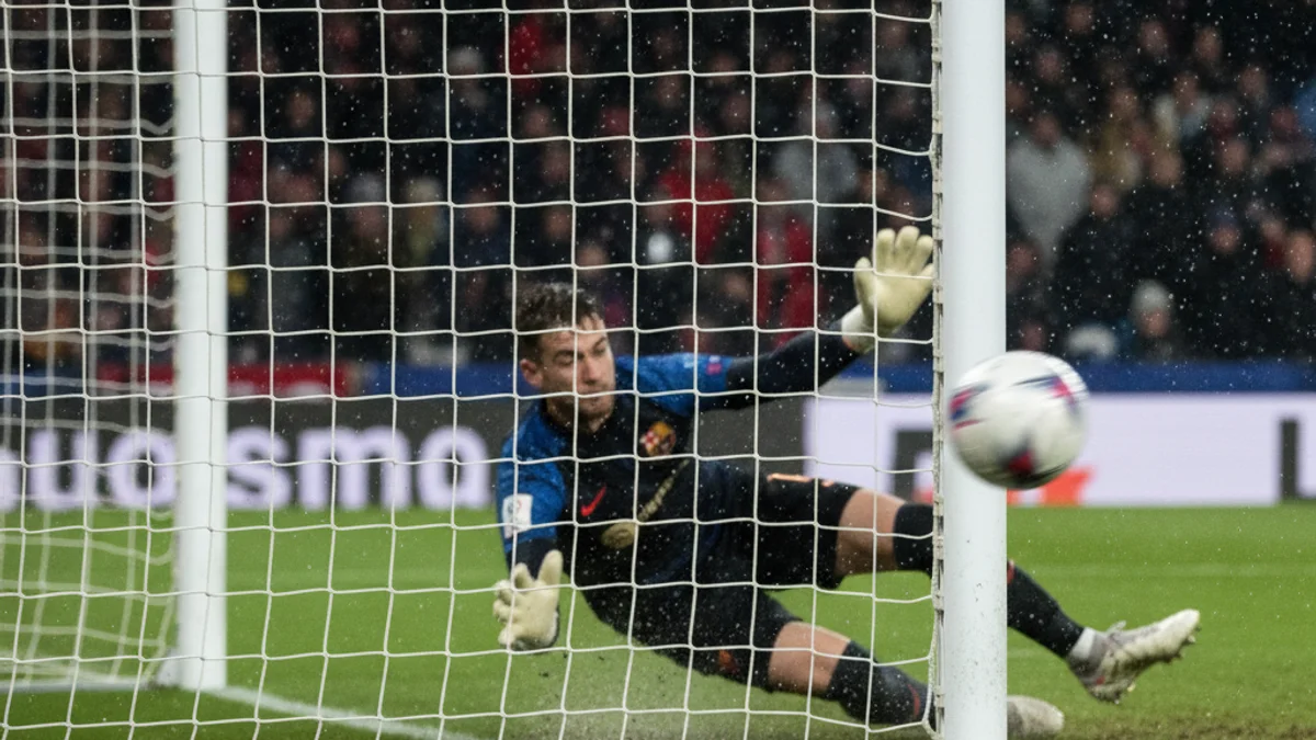 Imatge genèrica d'un partit de futbol, amb jugadors en acció defensiva prop de la porteria.
