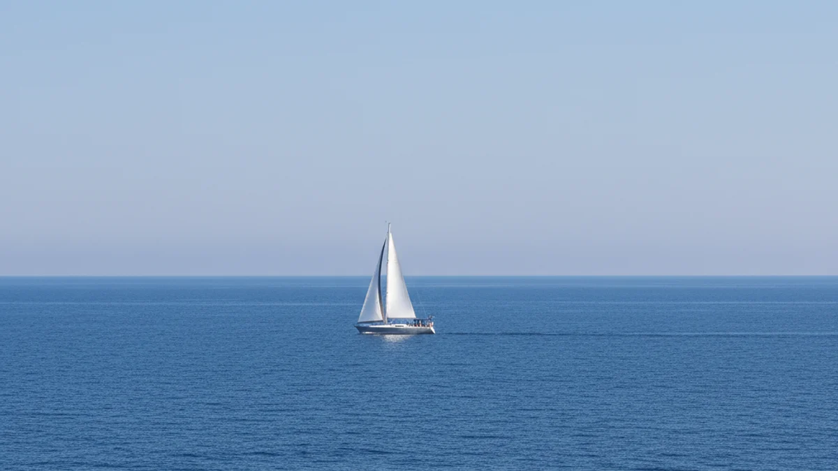 Imatge genèrica d'un veler navegant en aigües blaves amb l'horitzó clar i sense figures humanes recognoscibles.
