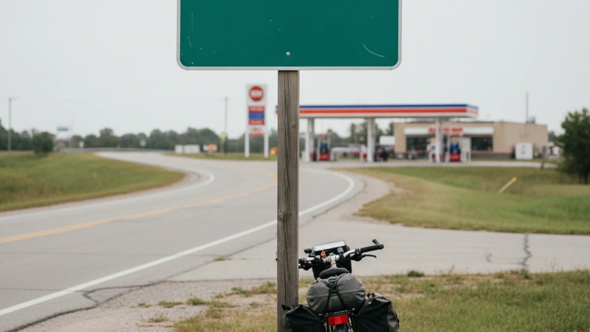 Imatge genèrica d'una benzinera a la sortida d'una carretera, amb una bicicleta a prop.
