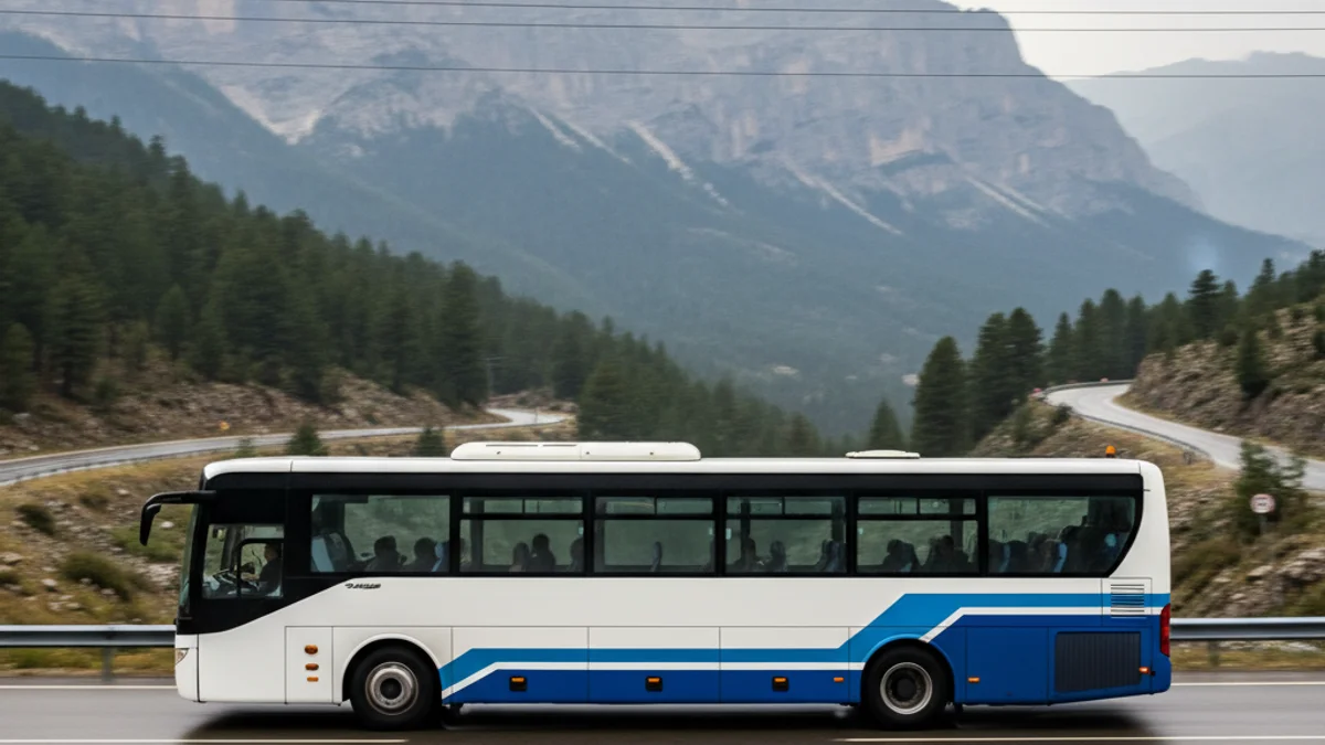 Imatge genèrica d'un autobús modern circulant per una carretera de muntanya amb un paisatge nevat de fons.