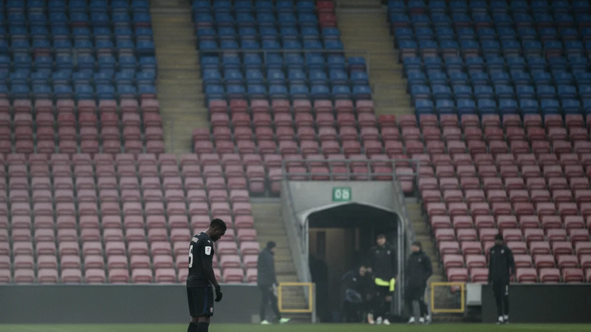 Vista d'un camp de futbol buit o parcialment il·luminat, simbolitzant la baixa moral i la crisi esportiva.