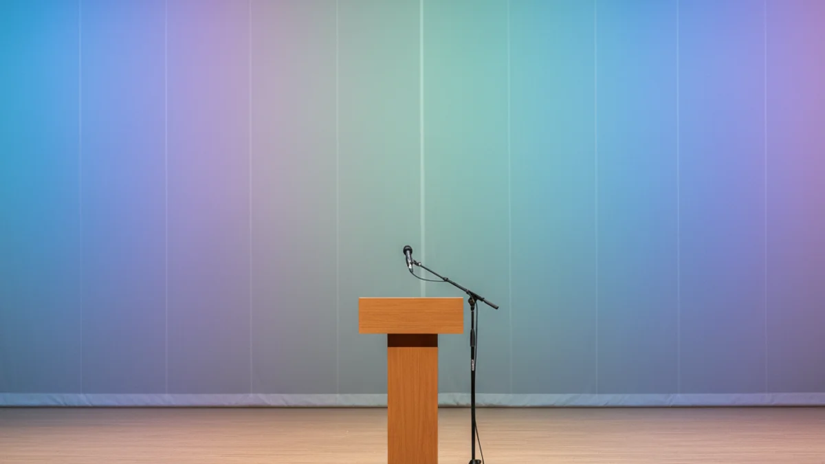 Un micròfon en un faristol sobre un escenari il·luminat, preparat per a l'inici d'un pregó o espectacle de comèdia.