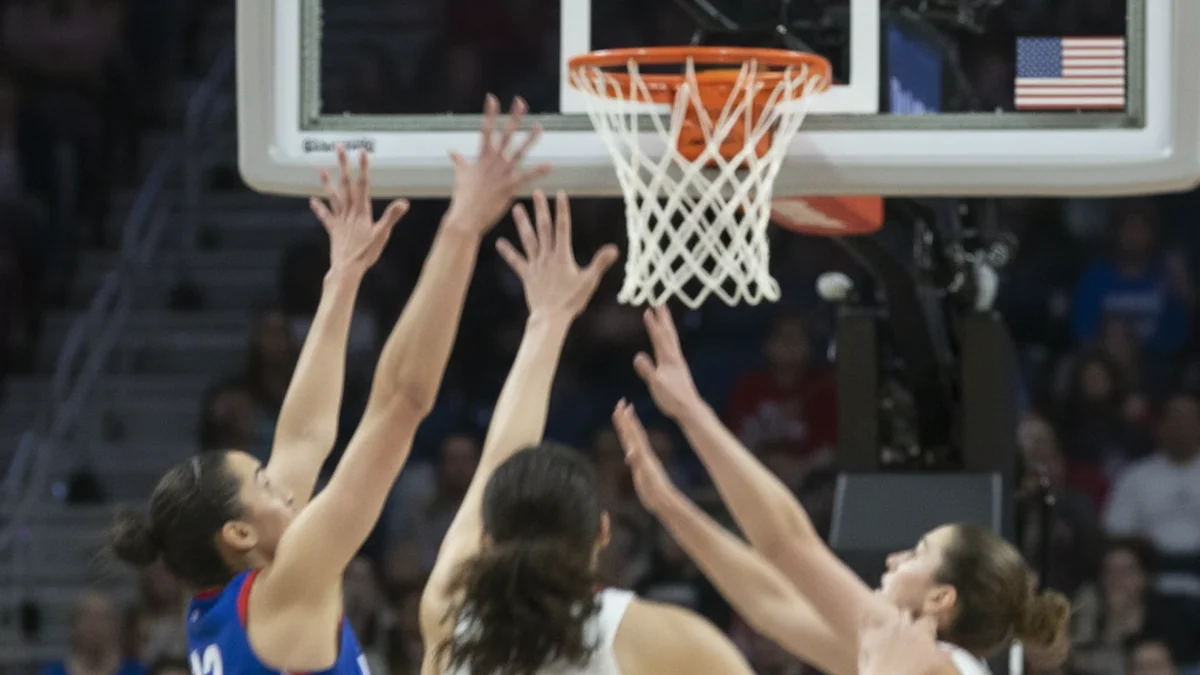 Imatge genèrica d'un partit de bàsquet femení amb jugadores en acció a prop de la cistella.