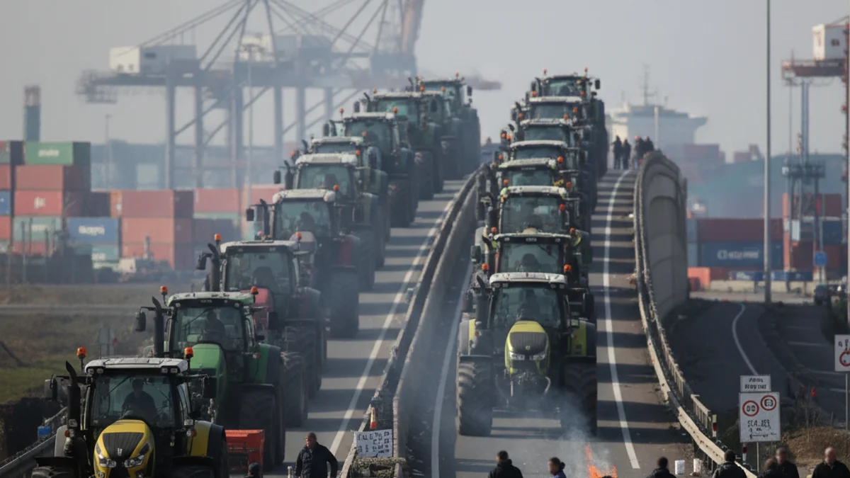 Imatge genèrica d'una protesta agrícola amb tractors bloquejant una carretera d'accés a un port industrial.