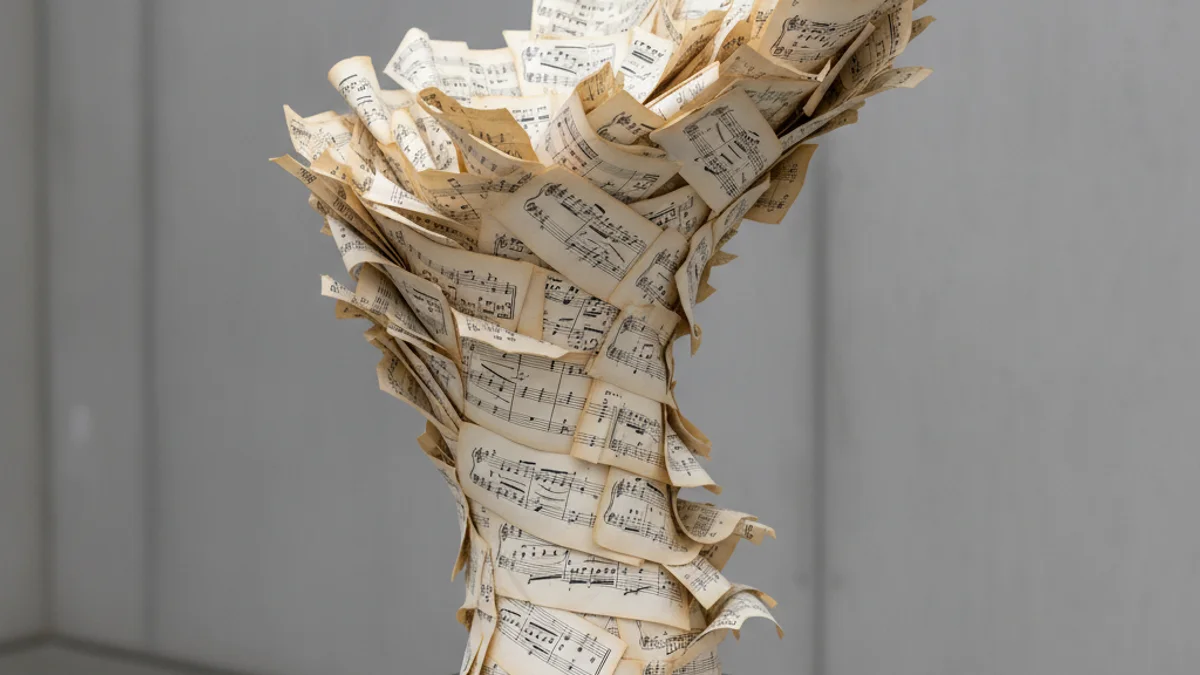 Representació abstracta d'un guardó o trofeu inspirat en partitures musicals i el moviment de l'aire.