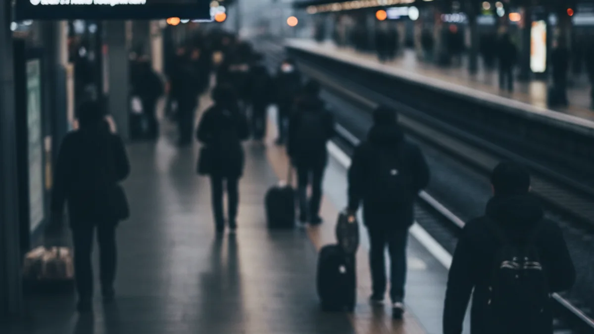 Imatge genèrica d'una andana de tren buida o amb figures borroses, simbolitzant retards i interrupcions del servei.