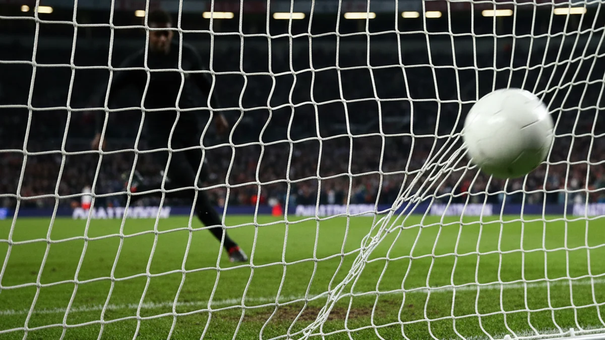 Imatge genèrica d'un partit de futbol on un jugador es prepara per xutar un penal.