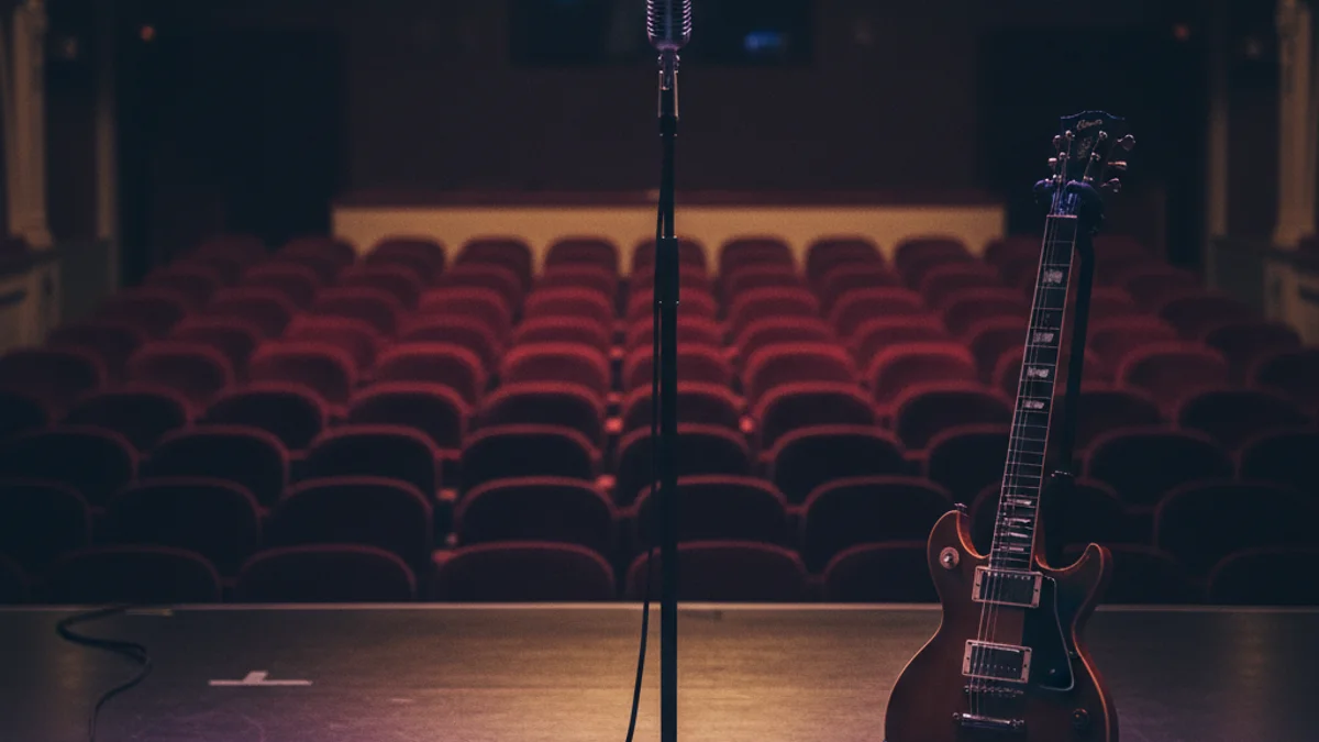 Generic image of a theater stage set up for a concert with warm lighting.