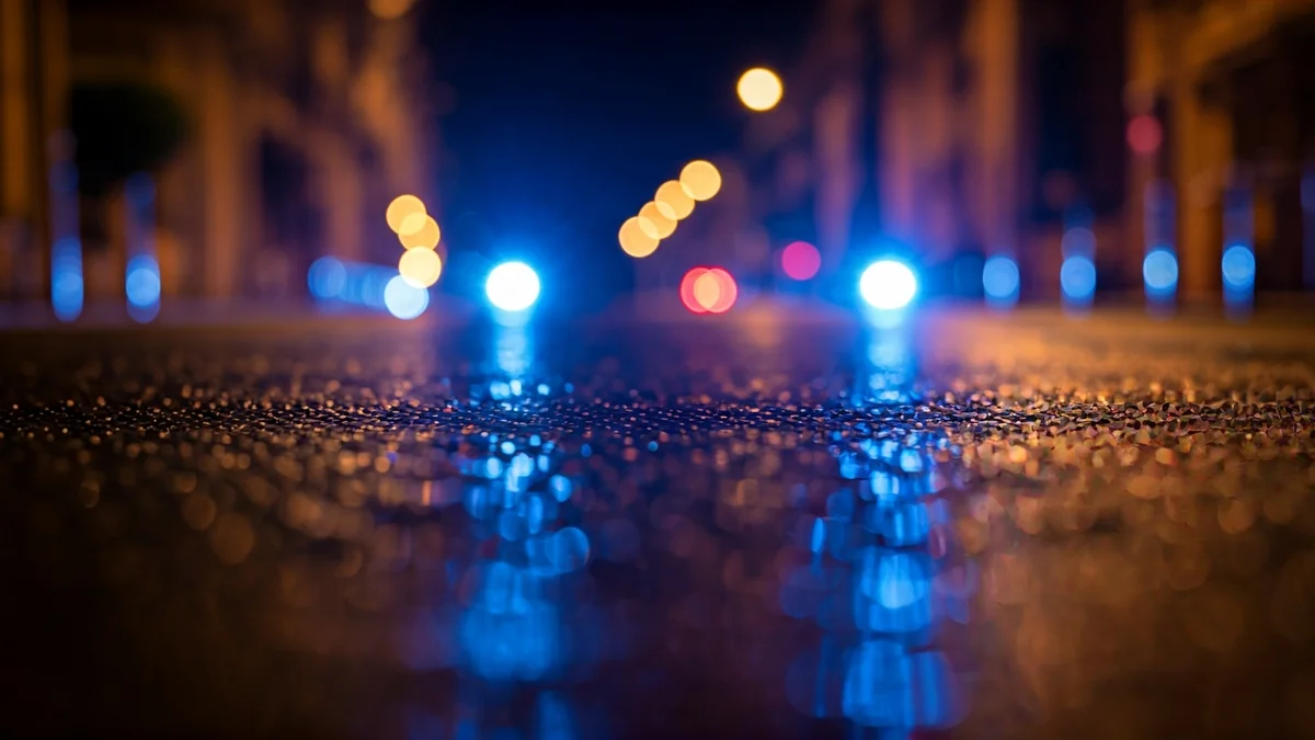 Imatge genèrica de llums d'emergència reflectint-se sobre l'asfalt mullat en una ciutat mediterrània.