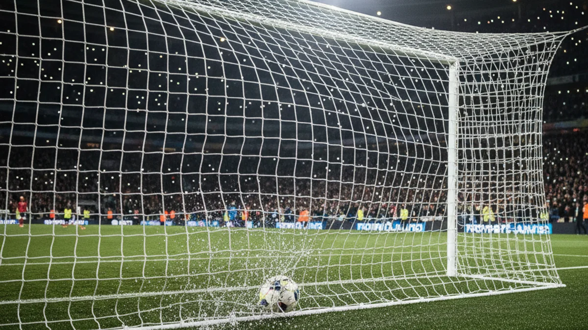 Imatge genèrica d'una pilota de futbol entrant a la porteria durant un partit nocturn.