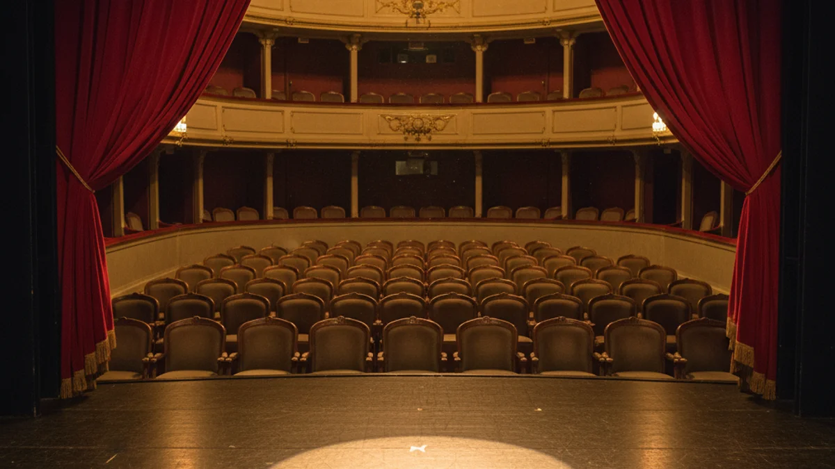 Imatge genèrica de l'escenari d'un teatre amb cortines vermelles i il·luminació càlida.