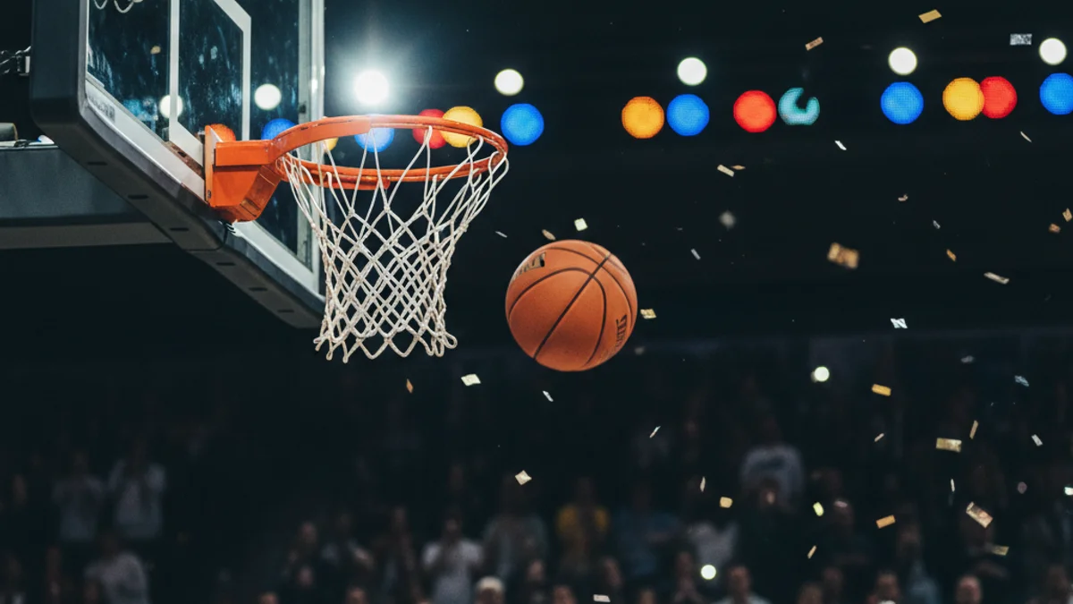 Imatge genèrica d'una cistella de bàsquet durant un partit professional amb públic al fons.