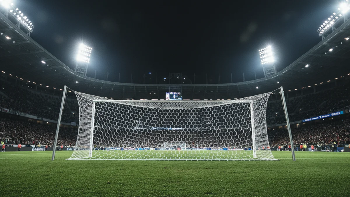 Imatge genèrica d'una porteria de futbol sota els focus d'un estadi durant un partit nocturn.