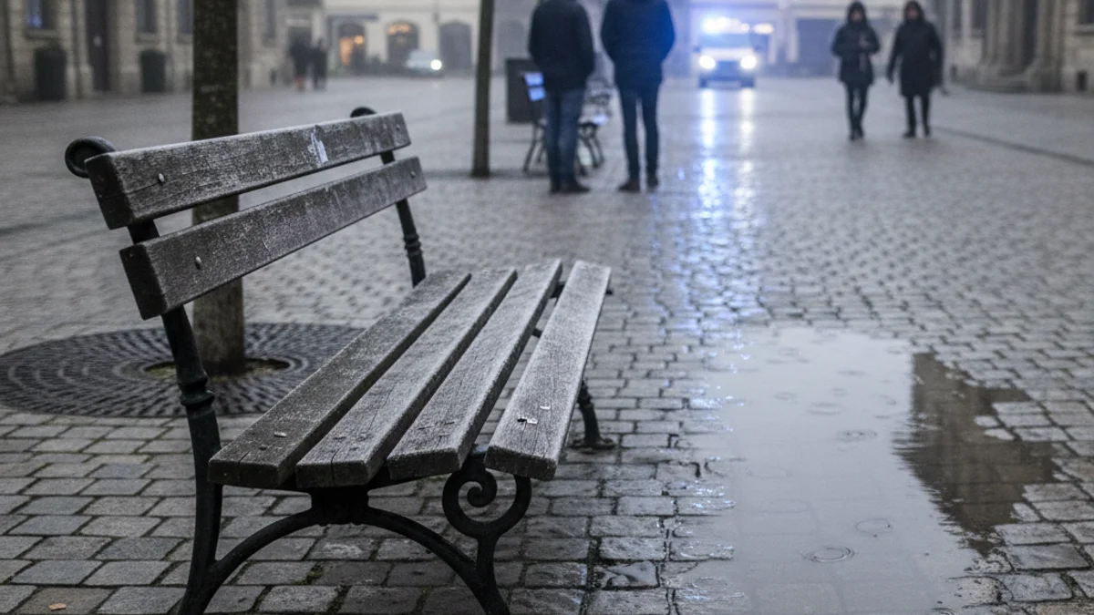 Imatge genèrica d'un banc buit en una plaça pública durant un matí gris.