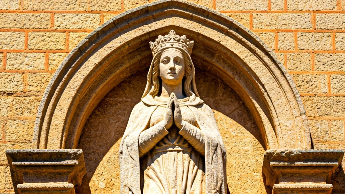 Imatge genèrica d'una escultura de pedra d'una santa en la façana d'una església.
