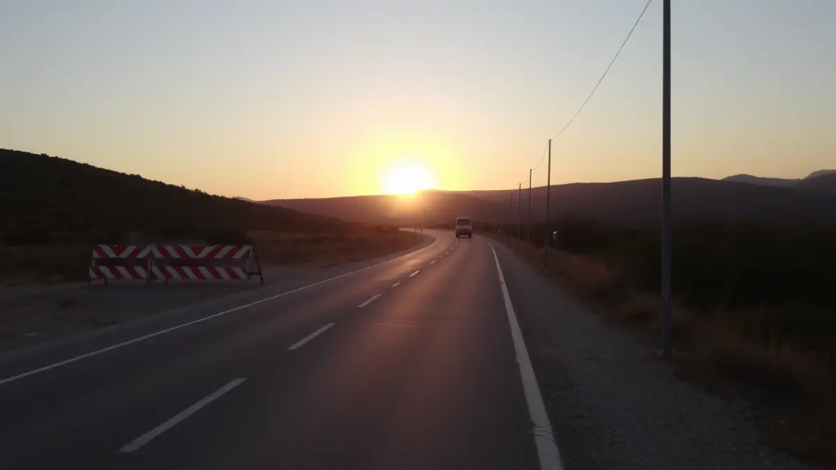 Imagen de unas obras en un camino rural con maquinaria y barreras de construcción.