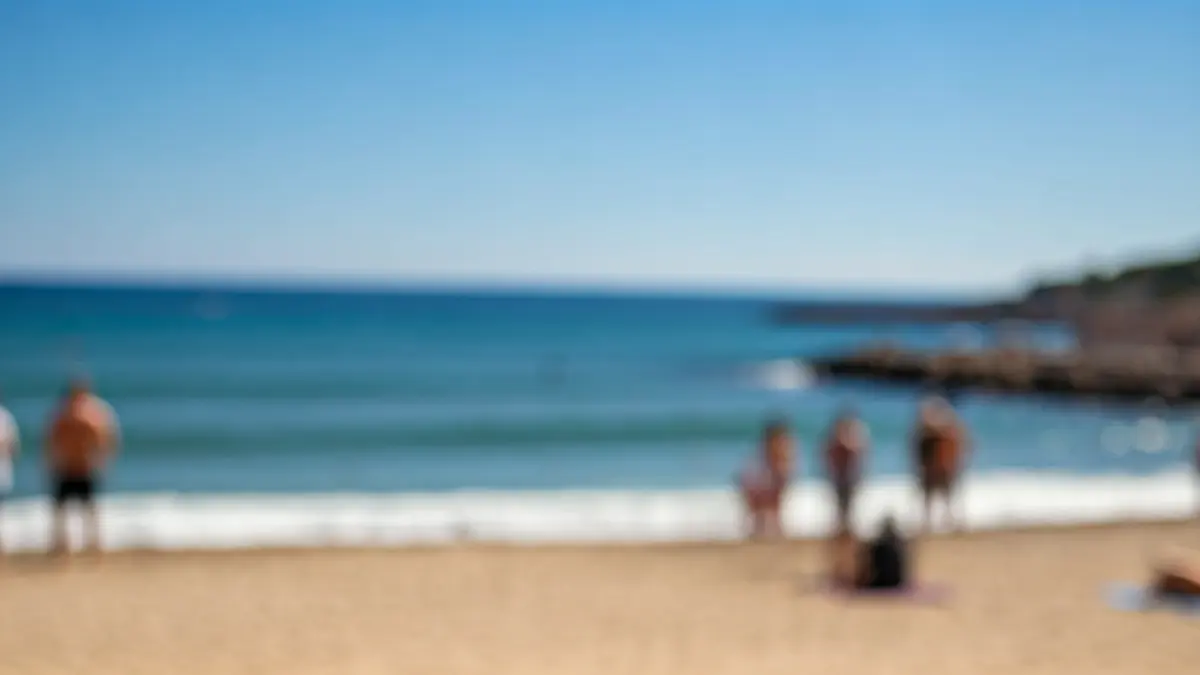 Imatge genèrica d'una platja mediterrània amb bon temps i gent gaudint de l'oci.