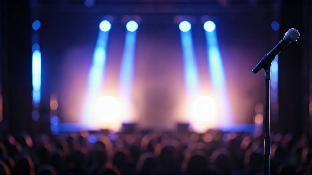 Generic image of a concert stage with blurred lights and a microphone.