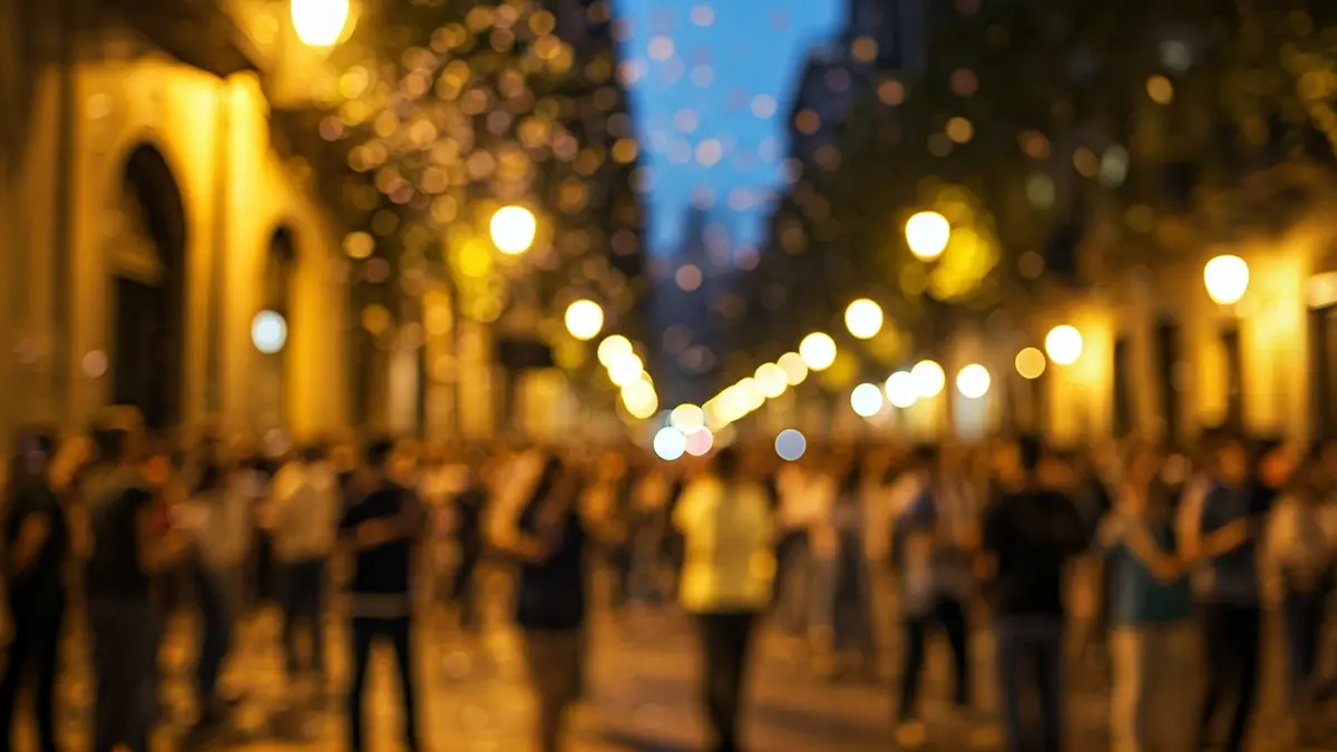 Imatge genèrica d'una multitud celebrant en un carrer de Barcelona amb confeti i llums.