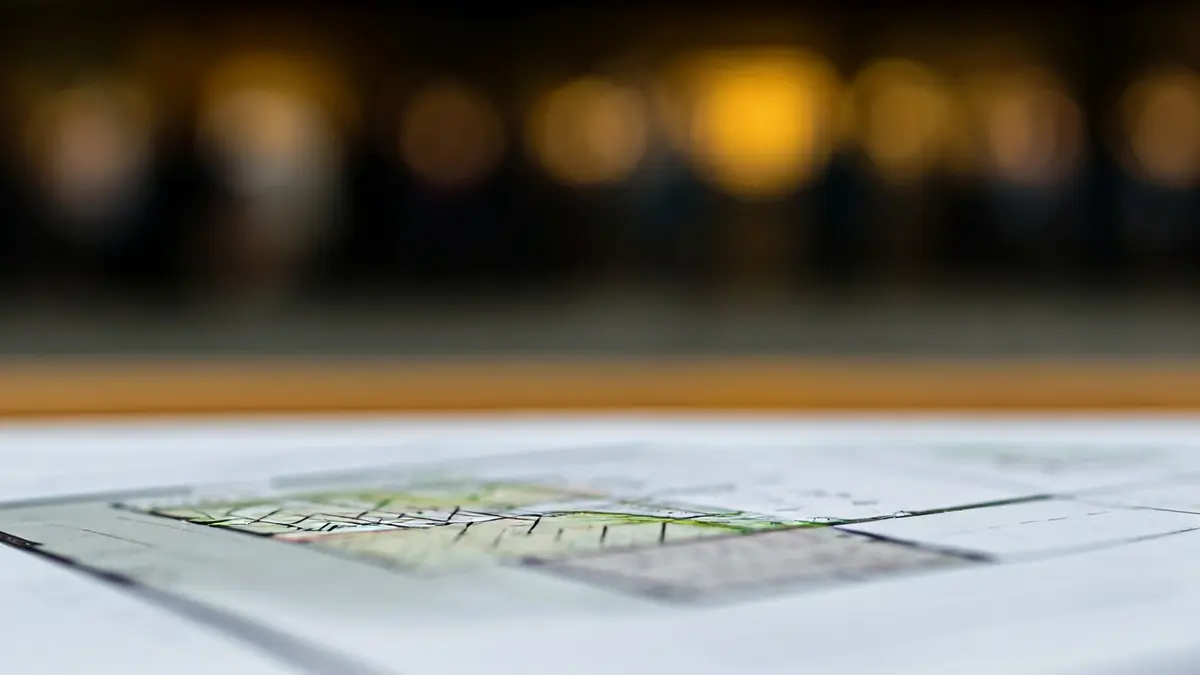 Imatge genèrica d'un document de planificació urbanística amb dibuixos arquitectònics borrosos.