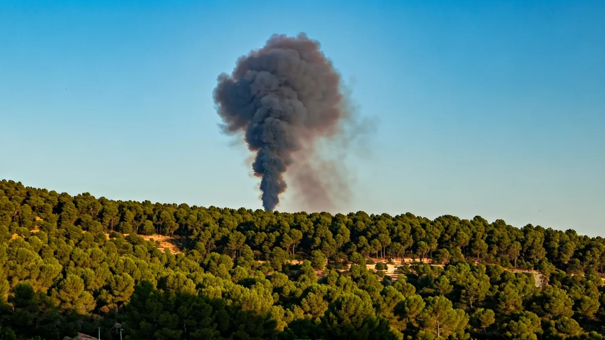Imagen genérica de una columna de humo sobre un bosque mediterráneo.