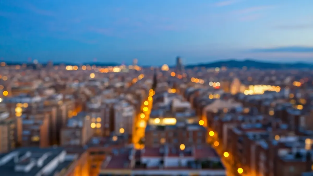 Generic image of a Barcelona cityscape at dusk, with residential buildings and city lights.