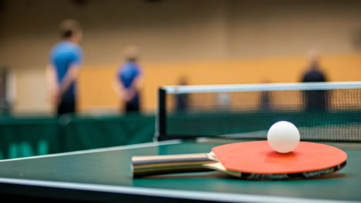Imagen genérica de una pala y una pelota de tenis de mesa sobre una mesa verde.