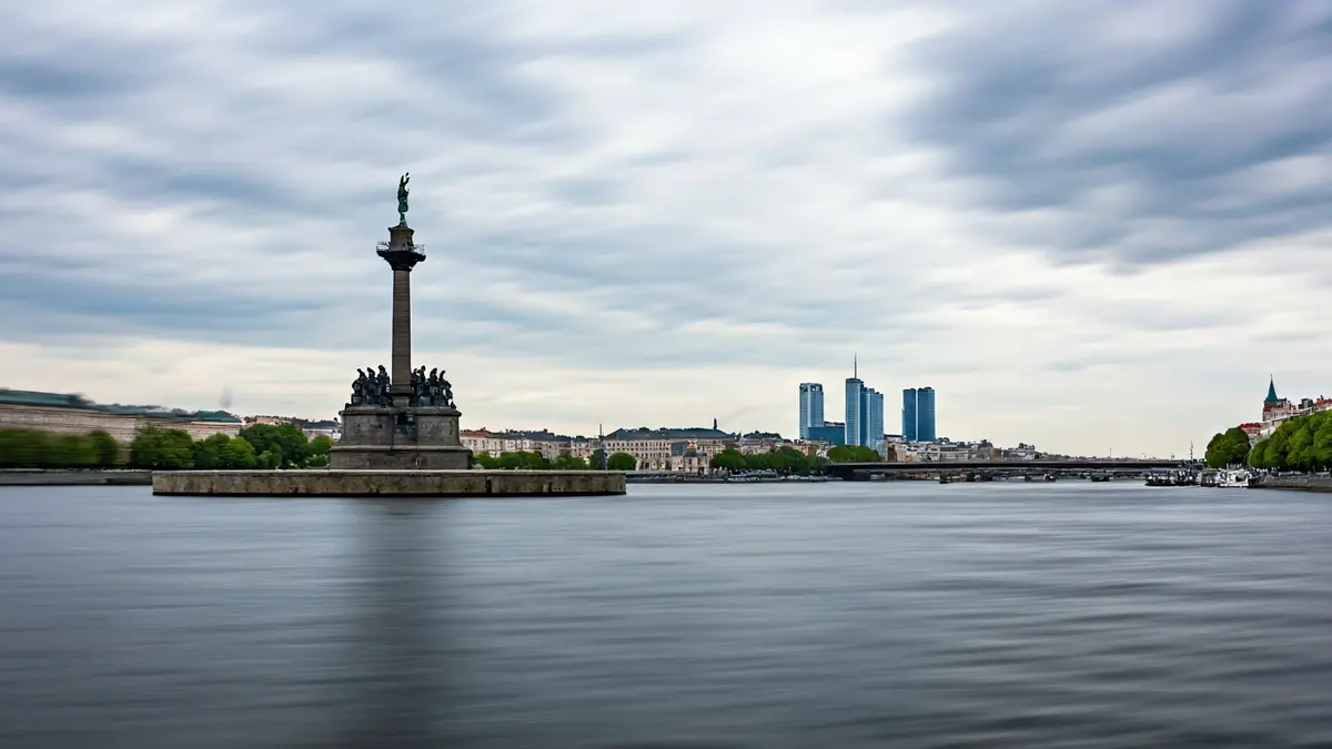 Imatge d'un monument al mig d'un riu, amb un paisatge urbà al fons.