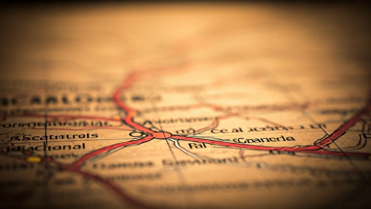 Mapa antic de Catalunya amb noms de llocs esborrats o reescrits, sota una llum càlida i històrica.