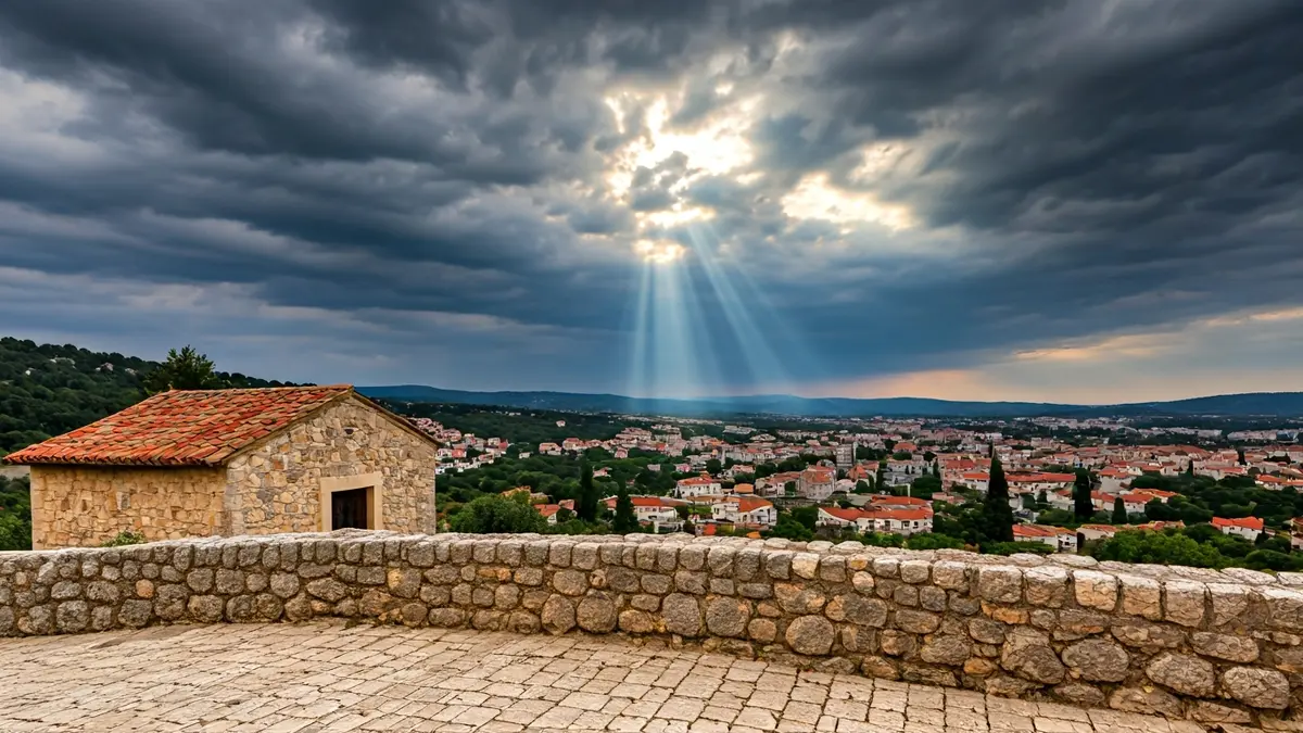 Imatge genèrica d'un raig de sol trencant un cel ennuvolat sobre un edifici de pedra, simbolitzant la claredat.