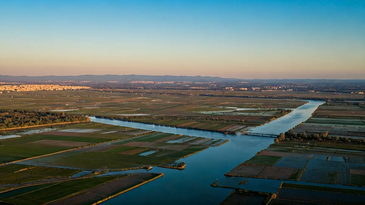 Vista aèria d'un paisatge de delta fluvial amb camps i zones urbanes