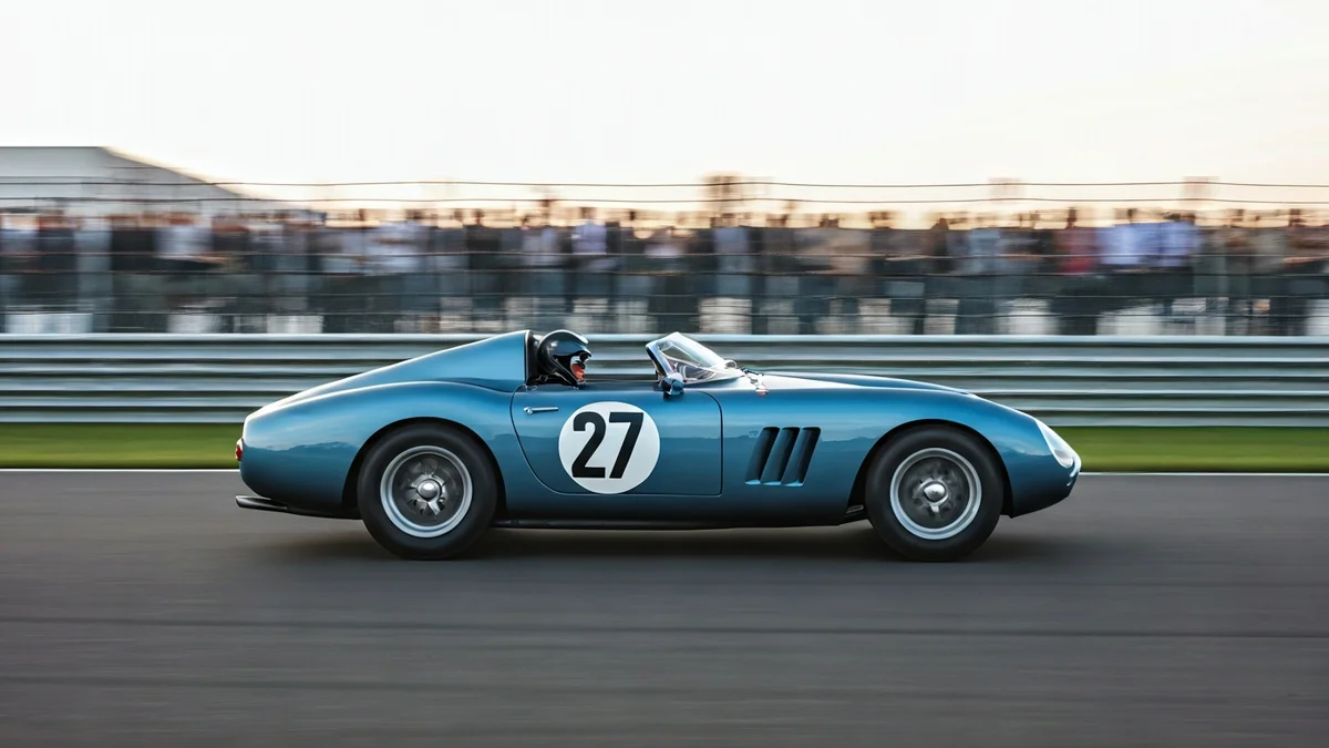 Imatge d'un cotxe clàssic de competició en un circuit, amb públic al fons.