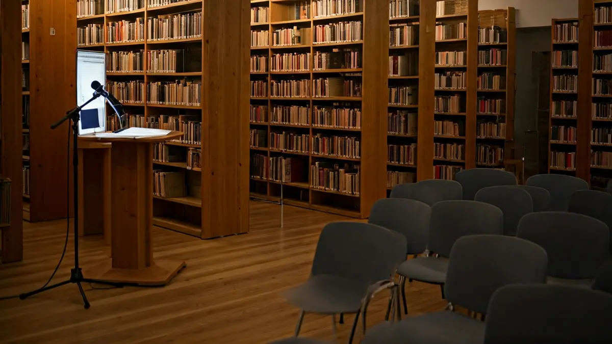 Imatge genèrica d'un interior de biblioteca o sala d'exposicions amb il·luminació càlida.