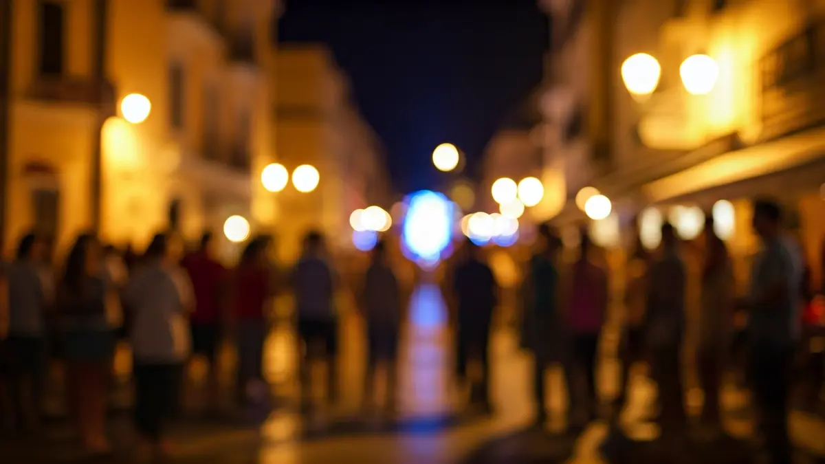 Imagen genérica de un festival de artes escénicas callejero con público y luces.