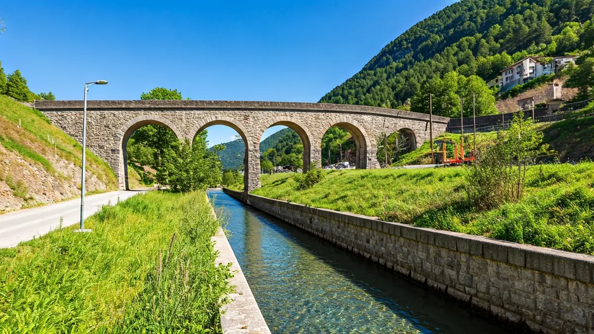Image of a historic water canal in a mountainous landscape.