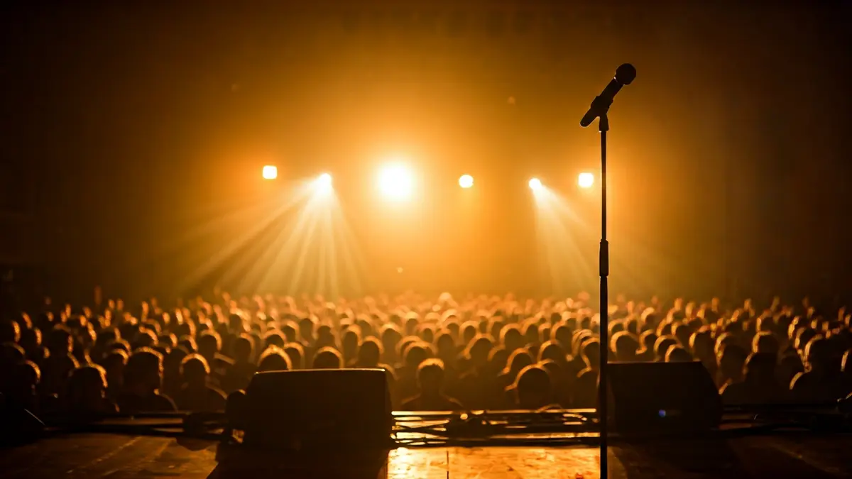 Imagen genérica de un escenario de concierto con focos y público difuminado.