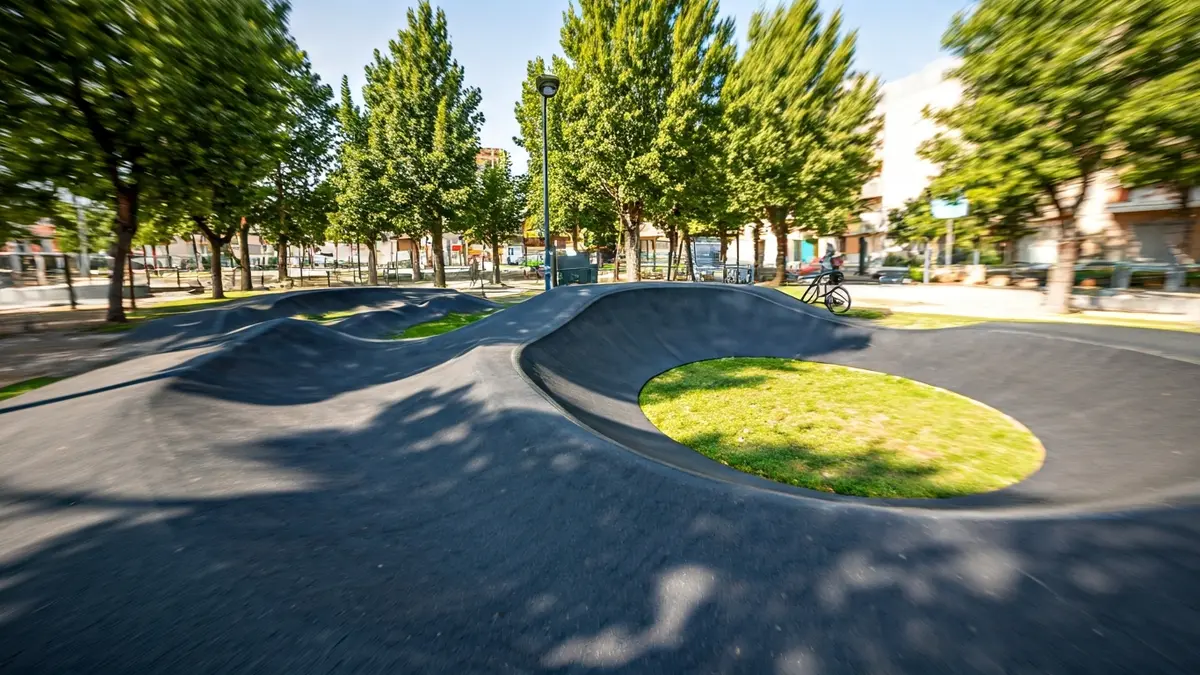 Imatge d'un pump track amb corbes i salts, apte per a bicicletes i patinets.