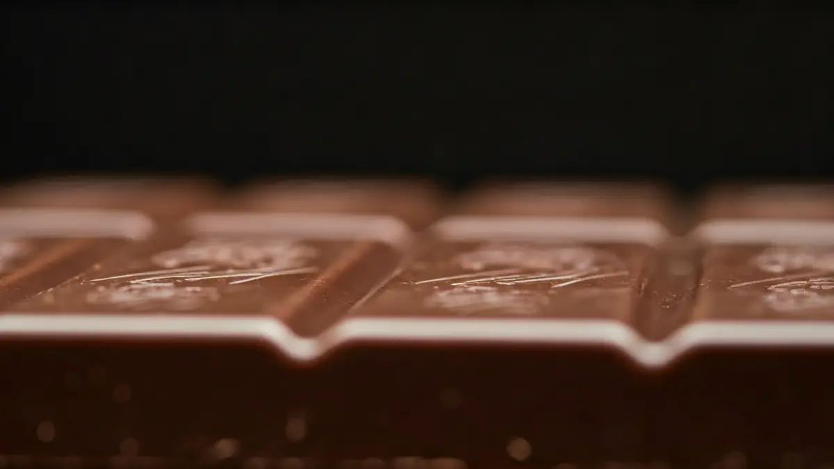 Imatge genèrica d'una rajola de xocolata amb una textura particular, destacant els detalls de la superfície.