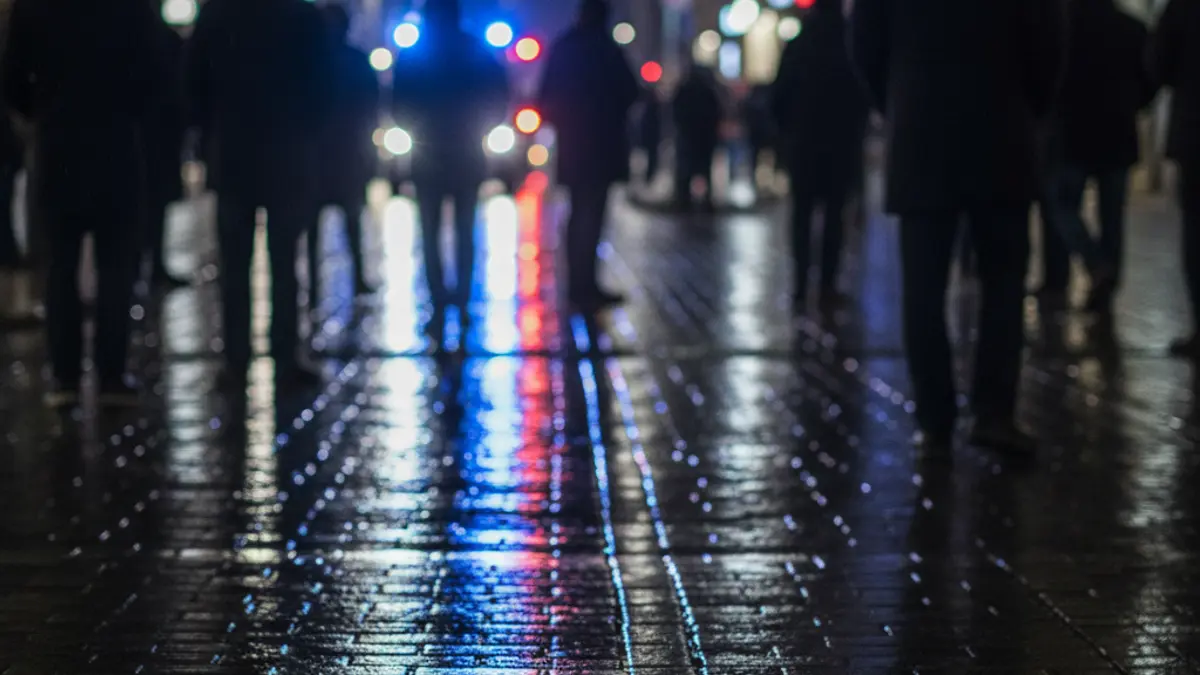 Generic image of emergency lights reflecting on wet asphalt in a city.