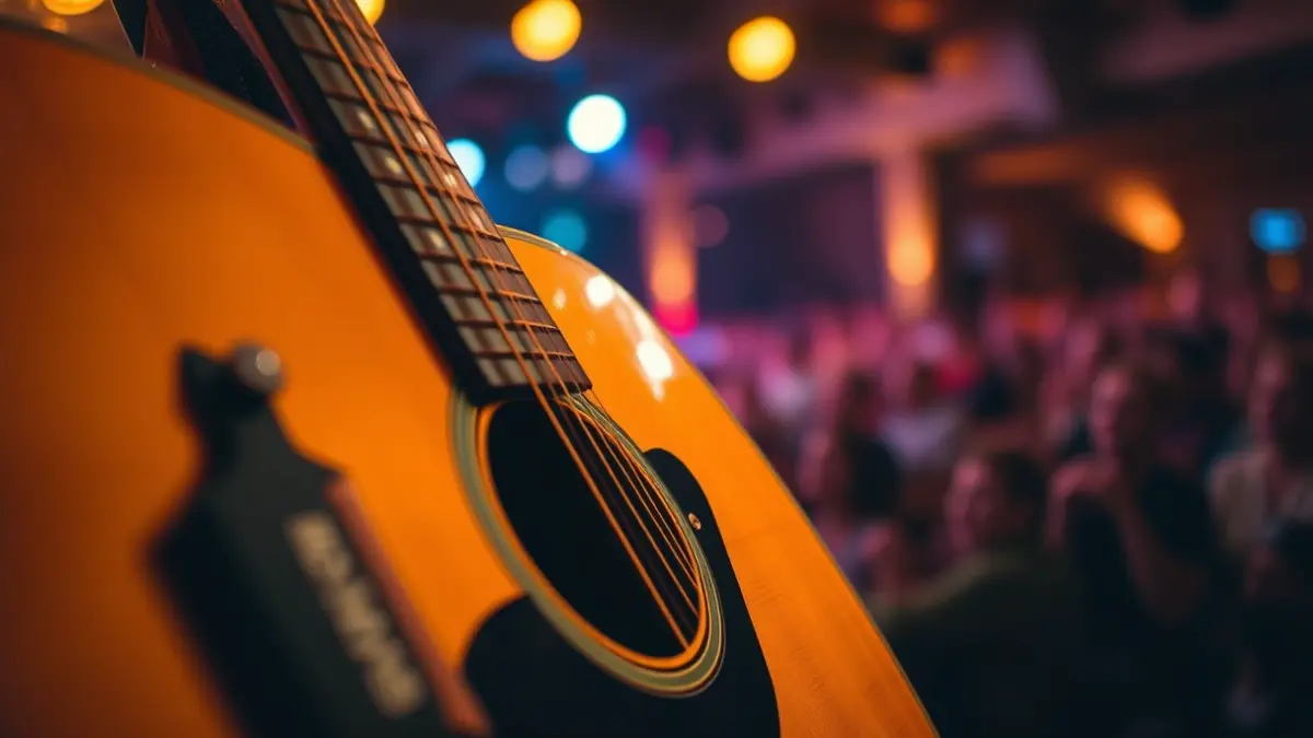 Generic image of an acoustic guitar on a stage with warm lighting.