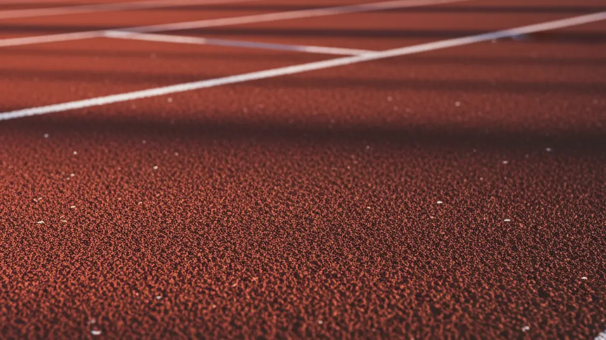 Imatge genèrica d'una pista d'atletisme amb la superfície vermella i les línies blanques.