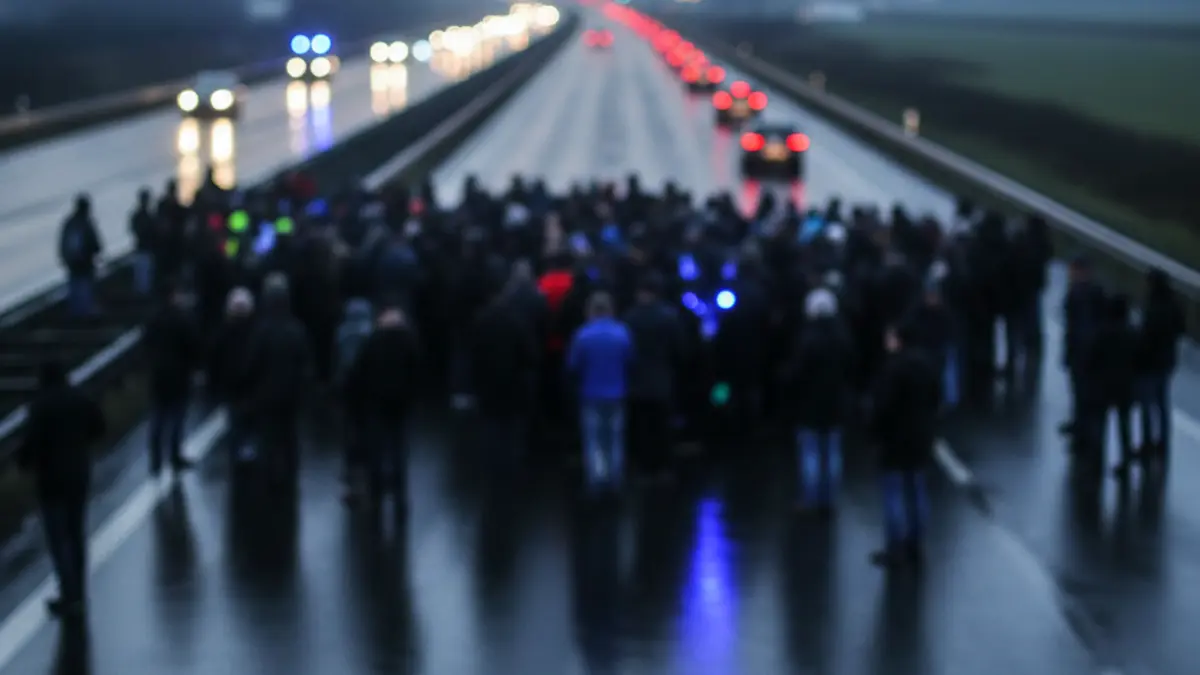 Generic image of a highway with emergency lights reflecting on wet asphalt at dawn, indicating a traffic disruption.