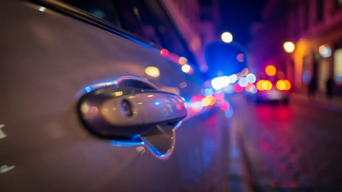 Generic image of police emergency lights reflected on a vehicle.