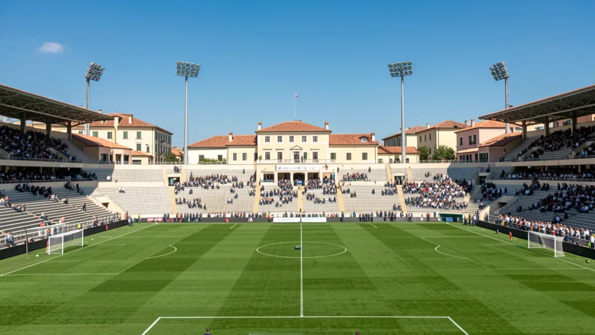 Exterior view of a football stadium with empty stands and green pitch.